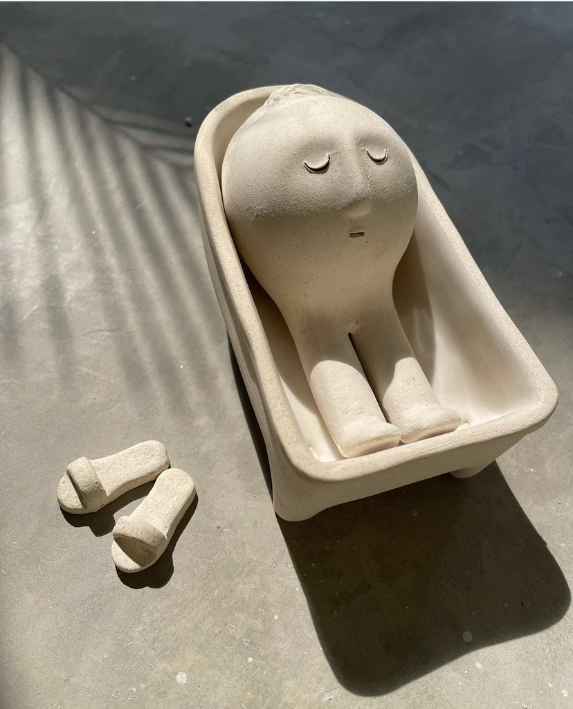 Sculpture of a person resting in a bathtub